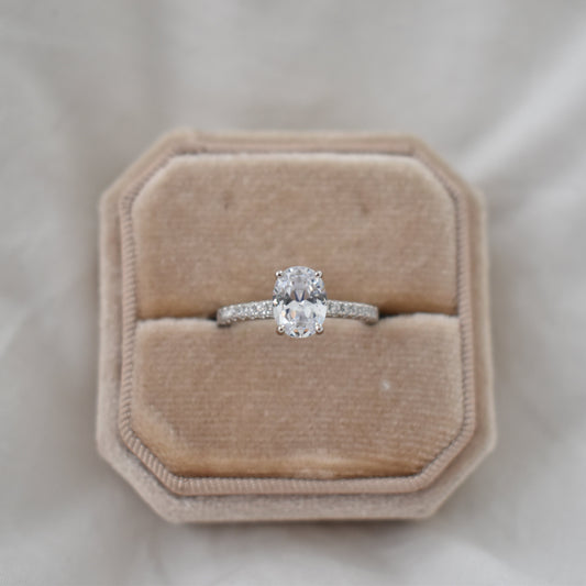 Silver or white gold ring with an oval-cut gemstone and a sparkling pavé band, presented as a keepsake ring or memorial jewelry.