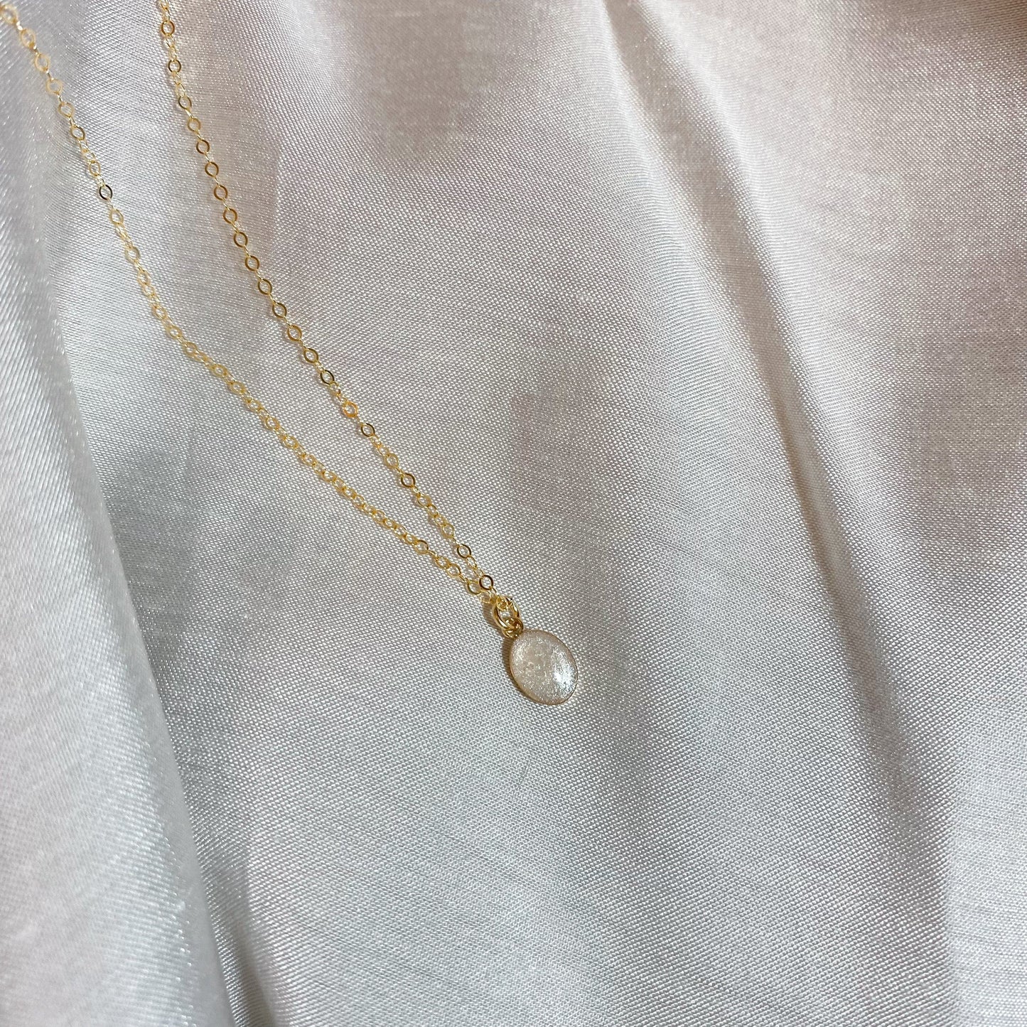 Simple gold chain necklace with a small, oval pendant, designed as a personalized cremation ashes jewelry piece or keepsake.