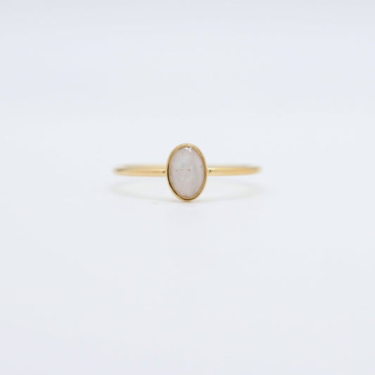 Simple gold ring with a single oval, opaque stone, designed as a cremation ring or memorial jewelry.