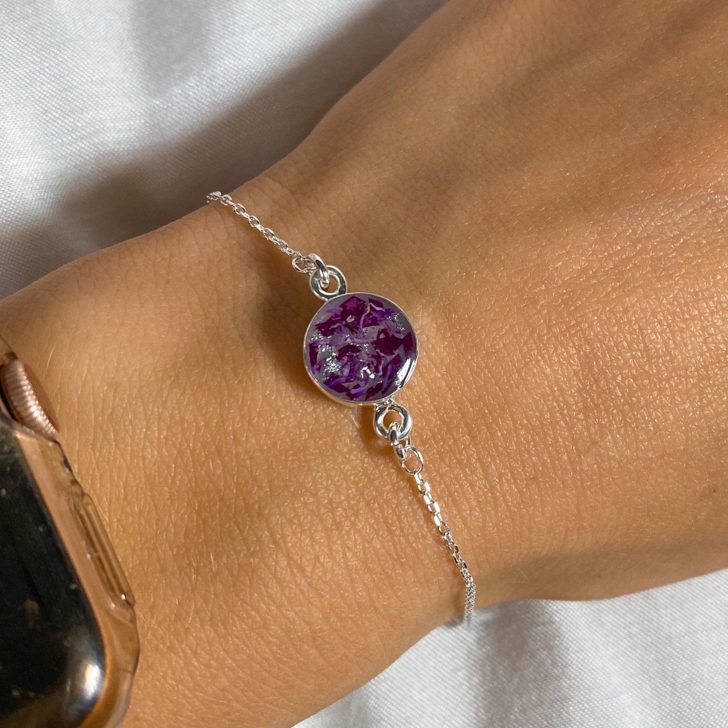 Silver bracelet with a round purple keepsake charm, featuring a unique memorial jewelry design.