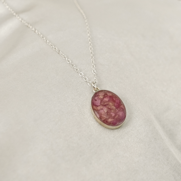 Necklace with an oval pink pendant, designed as a floral memorial jewelry piece or keepsake.