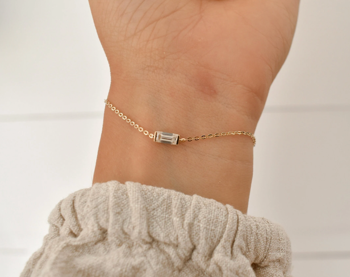 Gold chain bracelet with a horizontal baguette-shaped memorial stone, designed as a simple keepsake.
