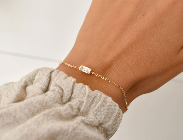 Gold chain bracelet with a horizontal baguette-shaped memorial stone, designed as a simple keepsake.