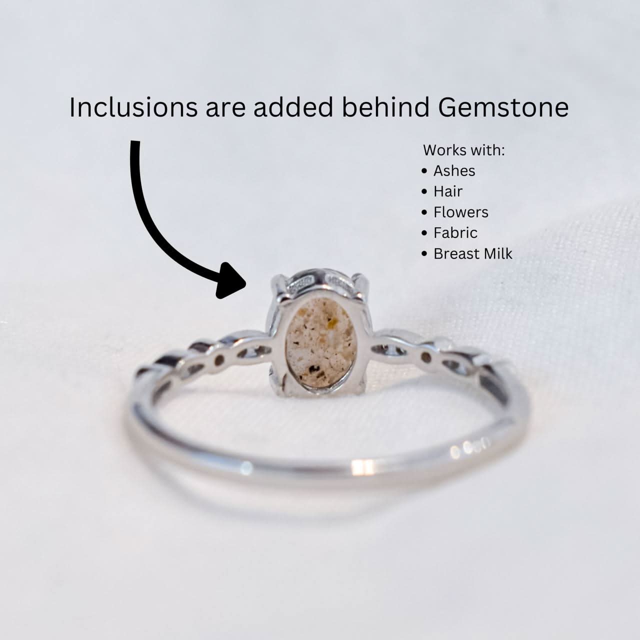 A silver braided-band cremation ring with an oval gemstone, containing ashes of a loved one, a perfect piece of memorial jewelry for a pet or human