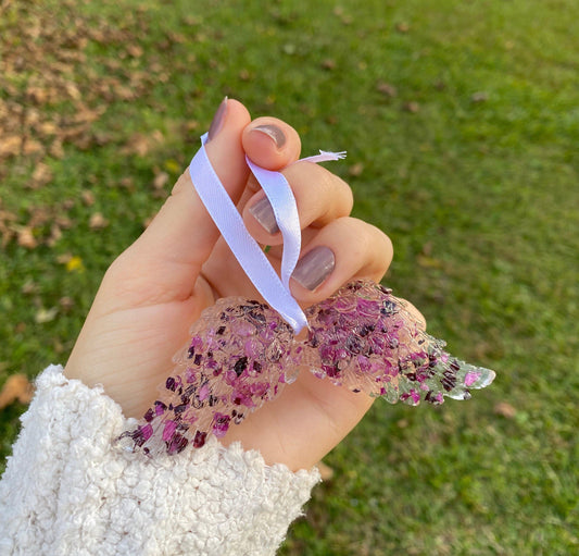 Personalized angel wings keepsake ornament with dried purple funeral flower petals and a white ribbon, a beautiful cremation keepsake for a loved one or a pet